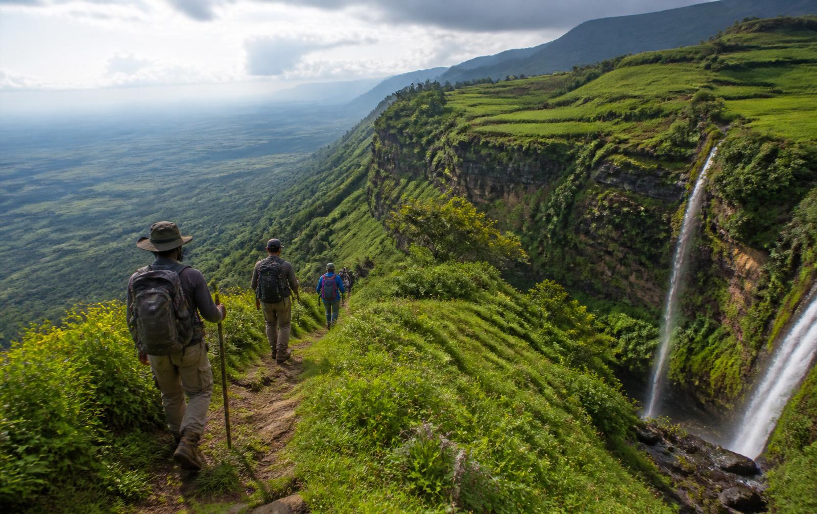 Hikers on a highland trail above the plains near Sipi Falls