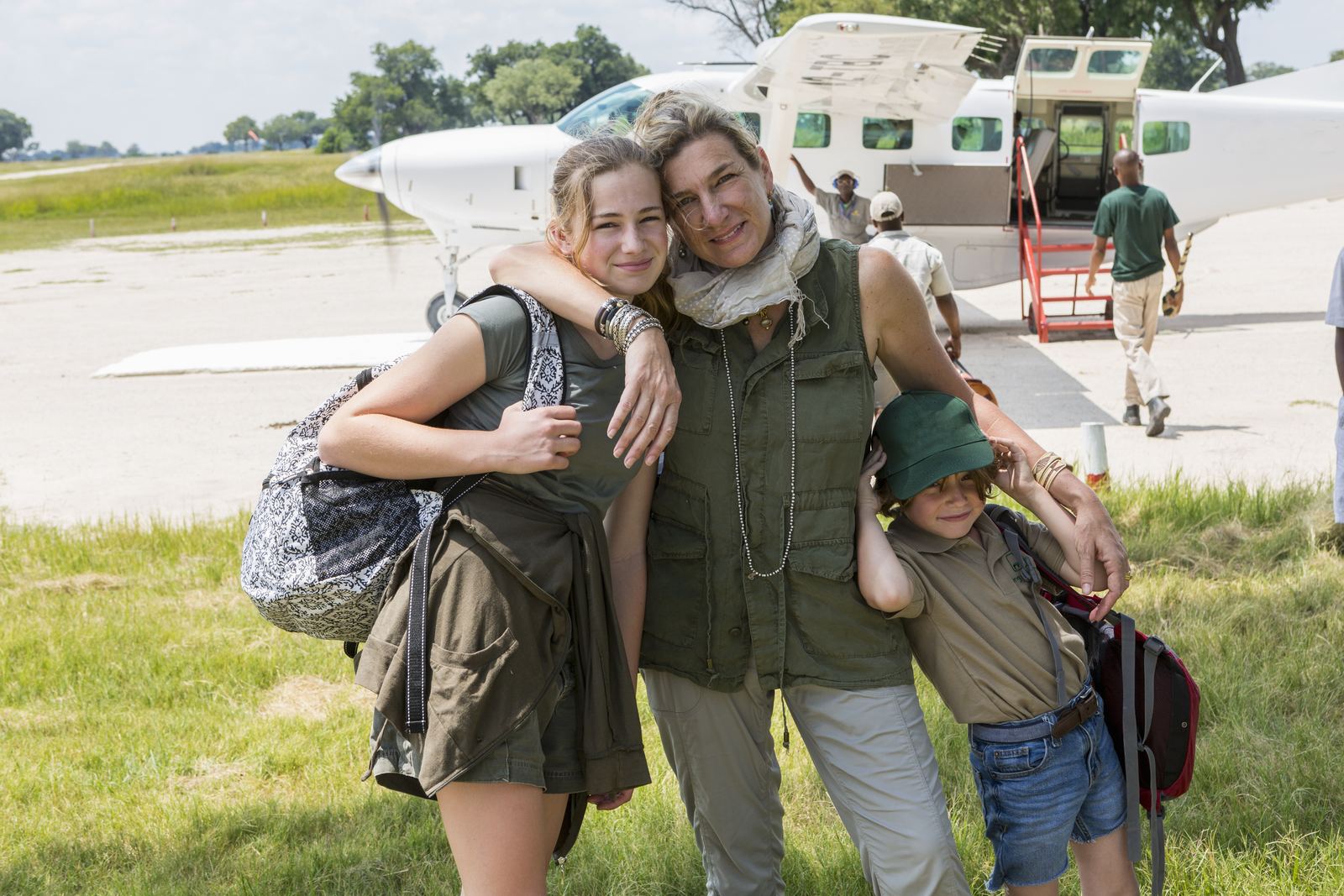 A family beside a private light aircraft on a bush airstrip